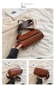 Detail of a brown cylindrical crossbody bag with a bohemian geometric patterned strap