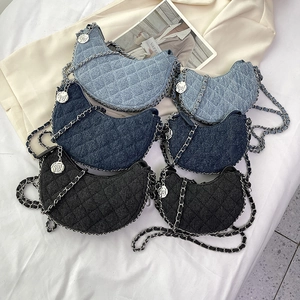 Bolsos de media luna de mezclilla acolchada con cadenas plateadas y dijes de camelia