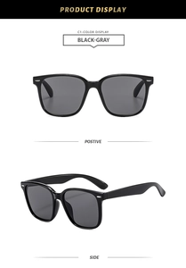 Detail view of black square sunglasses with grey lenses and silver metallic dots