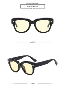 Détails d'une monture vintage noire avec verres jaunes et accents métalliques aux branches