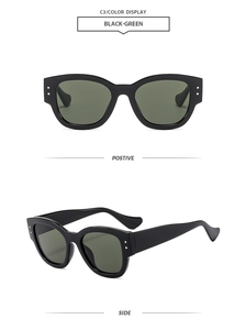 Detail of black thick frame sunglasses with silver rivets and dark green lenses