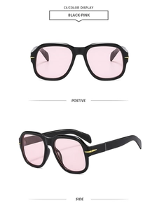 Macro view of black square sunglasses with pink lenses and golden arrow hardware