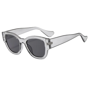 Fashionable translucent grey sunglasses with black lenses and rivet detail outdoors