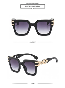 Detail of matte black square sunglasses with gold chain link design on the temples
