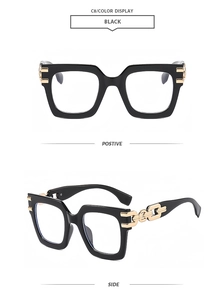 Detail view of black oversized square frames with golden chain link temple accents