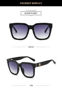 Detail view of square black sunglasses with gradient lenses and gold circular accents