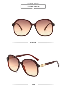 Close-up of oversized square sunglasses with tea gradient lenses and gold temple detail