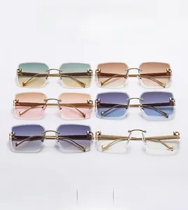 Detail view of six rimless gradient sunglasses with gold metal C-shape hinges