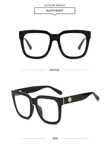 Detail view of square black frames featuring golden metal logo on the temple