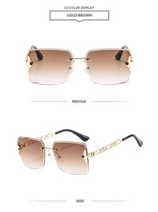 Close-up of frameless gradient sunglasses with gold chain temples and metal hardware