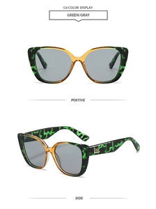 Detail view of green leopard cat eye sunglasses with gold logo and gray lenses
