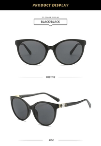 Detail view of black cat-eye sunglasses with golden geometric accents on temples