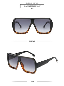Detail of square oversized flat top sunglasses in black leopard frame with gray lenses
