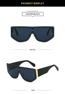 Front and side display of oversized black and gold shield sunglasses with metal rivets