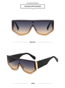 Detail view of large frame sunglasses with gold frames and gradient grey-brown lenses