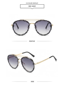 Detail of round sunglasses with gold floral lace frames and ink gray gradient lenses