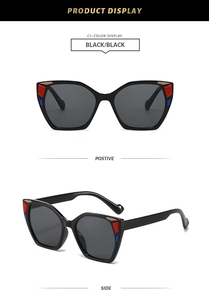 Detail of black cat-eye sunglasses featuring red and blue color-block accents on the frames