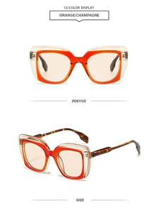 Detail view of large square sunglasses with orange inner frame and champagne outer layer