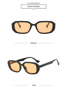 Detail of vintage square sunglasses with thick black frames and orange lenses
