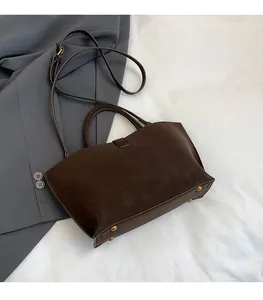 Detail of dark brown faux suede tote bag with gold-tone protective bottom studs