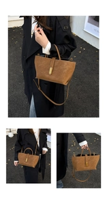 Detail of a brown suede bucket bag with gold buckle and adjustable crossbody strap