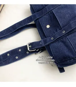 Detailed close-up of adjustable denim shoulder strap with silver buckle and eyelets