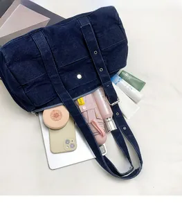 Detail view of large denim tote bag showing spacious interior with laptop and accessories