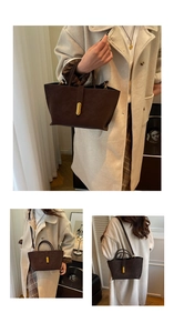 Detail of dark brown leather handbag with textured finish and gold oval twist lock closure