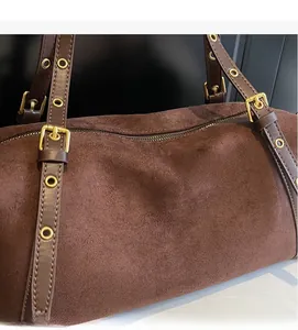 Macro shot of brown suede texture with leather straps and vintage gold metal hardware detail