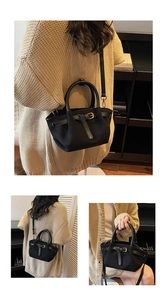 Dettaglio di una borsa tote nera con fibbia in pelle e accessori in metallo dorato