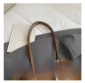 Vue détaillée du sac cabas en cuir marron avec surpiqûres blanches et boucles en métal