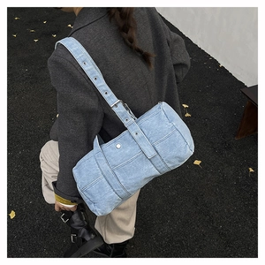 Macro view of light blue denim tote bag with contrast stitching and metal eyelets