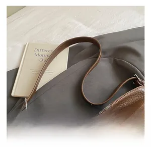 Detail of dark brown lychee texture leather tote bag with adjustable silver hardware