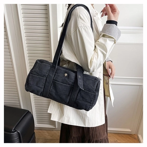 Detail of black denim tote bag with white contrast stitching and shoulder strap
