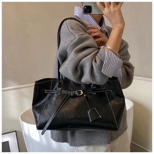 Détail du sac cabas en cuir noir avec surpiqûres blanches et boucle dorée élégante