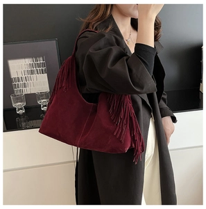 Detailed view of wine red suede hobo bag with long fringe tassels and retro finish