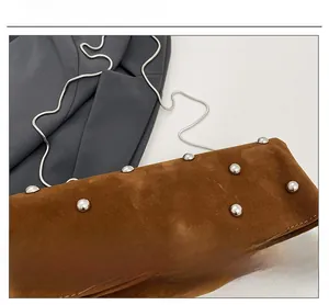 Detail of brown suede envelope bag with silver studs and snake chain strap