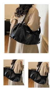 Detail of black pebbled leather tote bag with drawstring texture and metal buckle