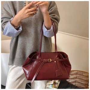 Détail du sac cabas en cuir bordeaux avec surpiqûres blanches et boucle décorative