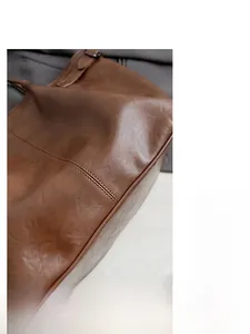 Detail view of brown faux suede tote bag showing durable stitching and premium texture