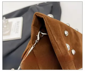 Detail of brown suede tote bag with silver ball rivets and sturdy metal chain strap