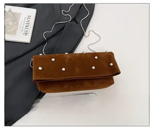 Detailed comparison of brown suede crossbody bag with silver studs and chain strap