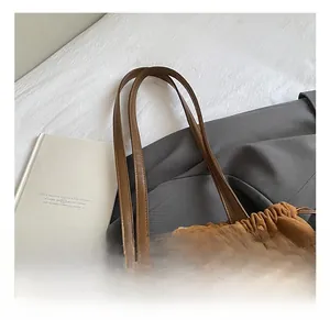 Gros plan du sac cabas en daim marron avec cordon de serrage et poignée découpée