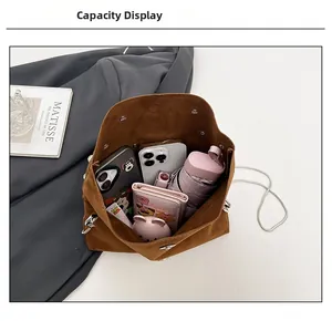 Brown faux suede crossbody bag showing large capacity with phone, wallet and umbrella