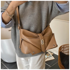 Detail of caramel brown litchi pattern leather shoulder bag with silver metal lock