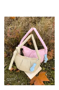 Quilted puff shoulder bags in pink and cream with knot detail and blue charm in autumn grass