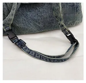 Detail of adjustable stitched denim shoulder strap with durable plastic buckle for comfort