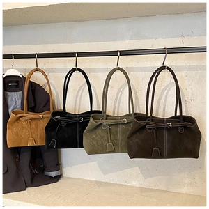 Détail de sacs cabas en daim multicolores avec surpiqûres et boucles décoratives