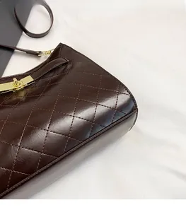 Detail of dark brown quilted leather surface and gold metal turn-lock closure on tote bag