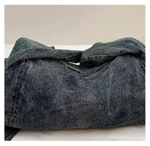 Detailed macro view of dark blue washed denim fabric with distressed texture and fine stitching
